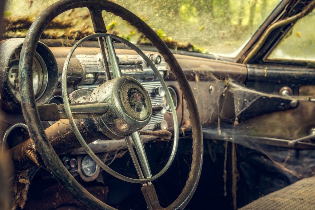 Bild einer schmutzigen Inneneinrichtung eines verrottenden Autos mit Spinnennetzen